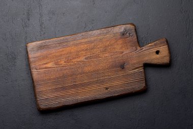 Wooden cutting board on stone kitchen table. Flat lay with copy space
