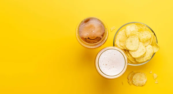 コピースペースのある鮮やかな黄色の背景にビールとチップの魅力的なスナック — ストック写真