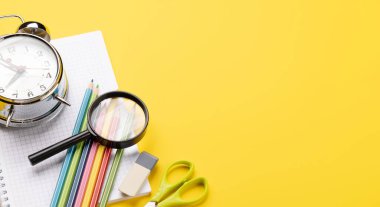 Okul malzemeleri ve sarı arka planda kırtasiye malzemeleri. Boş alanla