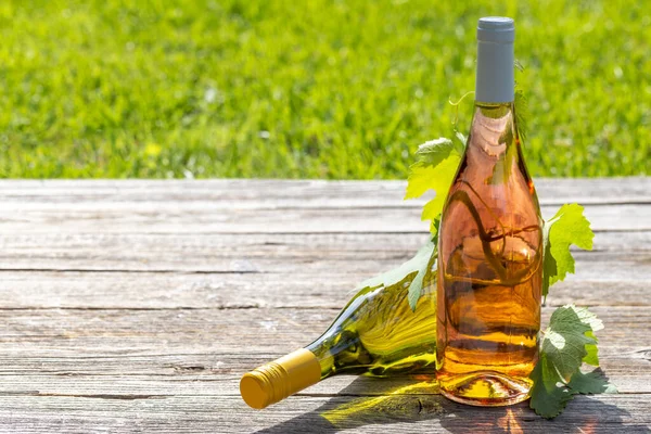 Weiß Und Rosenweinflaschen Auf Einem Gartentisch Freien Bilden Den Rahmen — Stockfoto