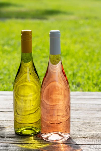 Butelki Białego Różanego Wina Stole Ogrodowym Świeżym Powietrzu Przygotowujące Scenę — Zdjęcie stockowe
