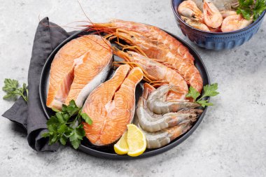 Karides, langoustine ve alabalık bifteği gibi taze deniz ürünlerinin üst görüntüsü.