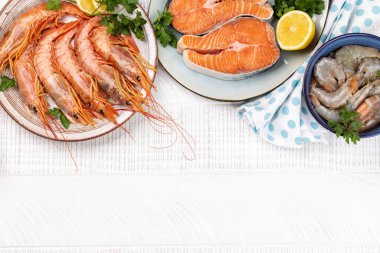 Karides, Langoustine ve alabalık bifteği gibi taze deniz ürünleri manzarası. Fotokopi alanı olan ahşap masanın üzerine yatıyordu.