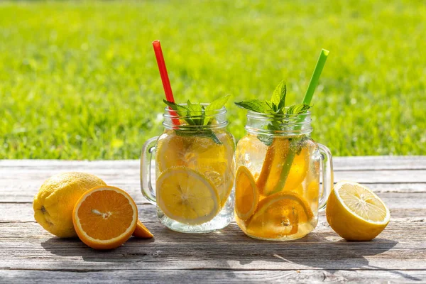 屋外のガーデンテーブルで提供される自家製レモネードをリフレッシュします 冷たい夏の飲み物 — ストック写真