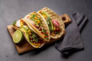 Meksika yemekleri, içinde et ve ızgara sebze olan takolar.