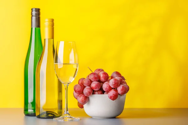 Vinflaskor Och Frodiga Druvor Visar Upp Konstnärskapet Vinframställning Med Kopieringsutrymme — Stockfoto