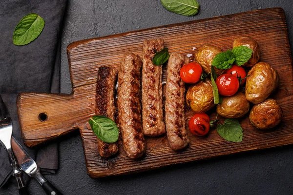 Delicious Grilled Sausages Potatoes Wooden Board Flat Lay — Stock Photo, Image