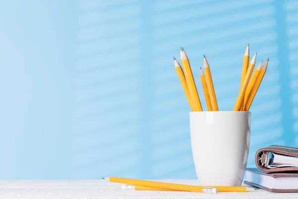 An organized arrangement of pencils and notepads on an office desk, offering ample copy space for your creative ideas or text
