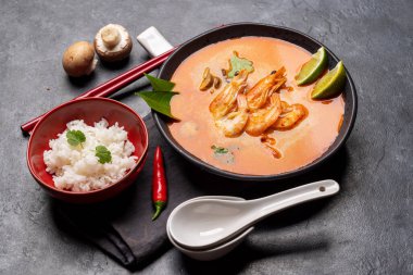Tayland Tom Yum Çorbası, deniz mahsulü ve bir kase pirinç.