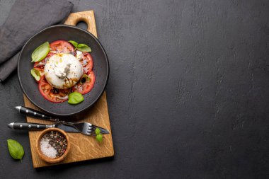 Antipasto with burrata cheese, tomatoes and basil. Italian cuisine. Flat lay with copy space