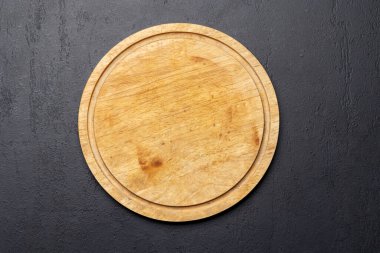 Wooden cutting board on stone kitchen table. Flat lay with copy space