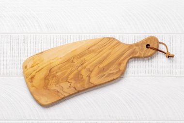 Wooden cutting board on kitchen table. Flat lay with copy space