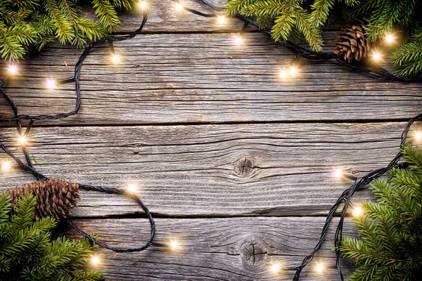 コピースペースと木製の背景にクリスマス輝くガーランドとモミの木の枝 — ストック写真