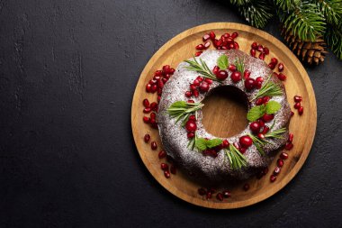 Nar tohumları, kızılcık ve biberiyeyle süslenmiş Noel pastası. Kopyalama alanı olan düz