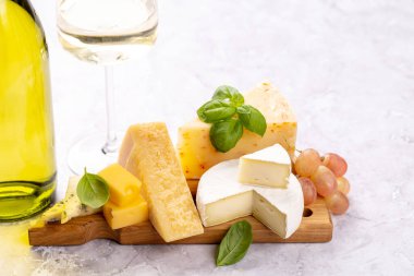 Various cheese on board and white wine