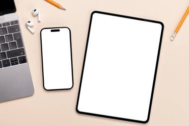 Masadaki boş beyaz ekran akıllı telefon ve tablet, tasarım modeliniz için mükemmel.