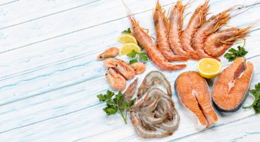 Karides, Langoustine ve alabalık bifteği gibi taze deniz ürünleri manzarası. Kopyalama alanı olan düz