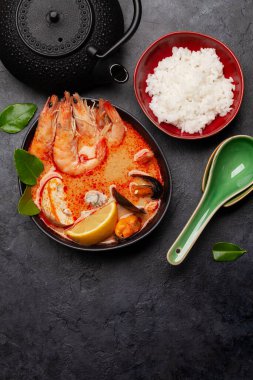 Geleneksel Tayland çorbası Tom Yum kung deniz ürünleri, hindistan cevizi sütü, biber ve pirinç kasesi. Üst görünüm düzlüğü kopyalama alanı ile yatıyordu
