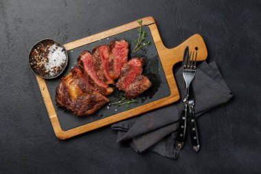 Lezzetli bir şekilde dilimlenmiş biftek, mükemmel pişmiş ve tadını çıkarmaya hazır. Düz yatıyordu