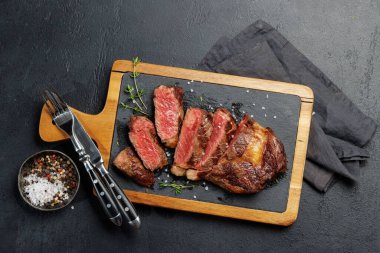 Lezzetli bir şekilde dilimlenmiş biftek, mükemmel pişmiş ve tadını çıkarmaya hazır. Düz yatıyordu