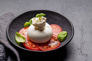Antipasto with burrata cheese, tomatoes and basil. Italian cuisine