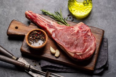 Çiğ Tomahawk bifteği ve baharatları. Izgara için hazır.