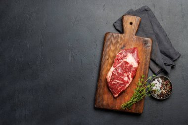 Çiğ biftek, taze ve pişmeye hazır, ağız sulandırıcı bir yemek deneyimi vaat ediyor. Kopyalama alanı olan düz