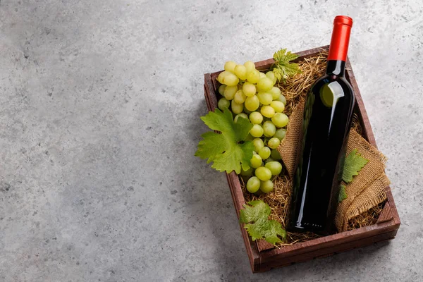 一个红葡萄酒瓶和新鲜的葡萄 放在一个乡村木箱里 有复制空间 — 图库照片