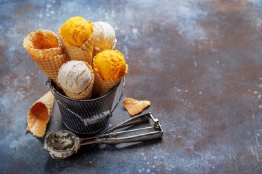 Lezzetli waffle külahlarında çeşitli dondurma aromaları, her tat tomurcuğu için bir ikram. Kopyalama alanı olan taş arkaplan