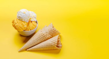 Çeşitli dondurma tatları ve nefis waffle külahları. Her tat için bir ikram. Fotokopi alanı olan sarı arkaplan üzerinde düz uzanır