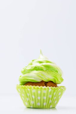 Green cupcake on grey background with copy space