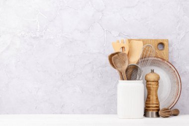 Kitchen utensils on wooden table. Front view with copy space