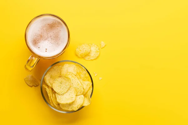 コピースペースのある鮮やかな黄色の背景にビールとチップの魅力的なスナック — ストック写真
