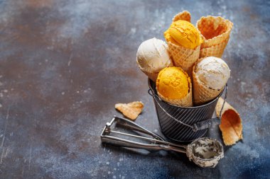 Lezzetli waffle külahlarında çeşitli dondurma aromaları, her tat tomurcuğu için bir ikram. Kopyalama alanı olan taş arkaplan