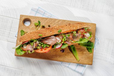 Delicious sandwich stuffed in a fresh baguette, bursting with flavor and wholesome ingredients. Flat lay