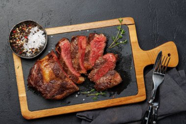 Lezzetli bir şekilde dilimlenmiş biftek, mükemmel pişmiş ve tadını çıkarmaya hazır. Düz yatıyordu