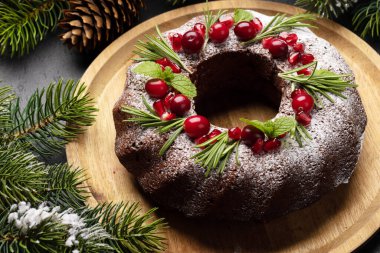 Nar tohumları, kızılcık ve biberiyeyle süslenmiş Noel pastası.