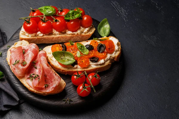 Lezzetli bir bruschetta seti sulu domates, peynir ve lezzetli prosciutto ile süslenmiş. Kopyalama alanı ile