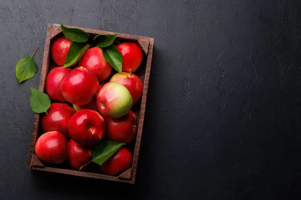 石のテーブルに新鮮な赤いリンゴが付いている木箱 コピースペースとフラットレイ — ストック写真