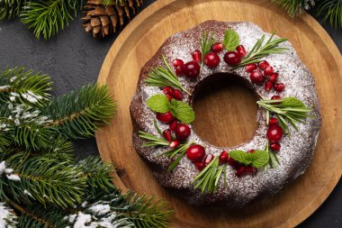 Nar tohumları, kızılcık ve biberiyeyle süslenmiş Noel pastası. Düz yatıyordu