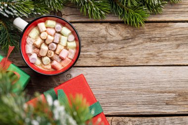 Marshmallow ve xmas hediye kutularıyla dolu bir fincan. Fotokopi alanı olan Noel tatili