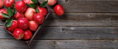 Tahta masada taze kırmızı elmalar olan tahta kutu. Kopyalama alanı olan düz