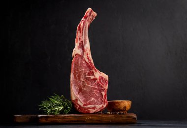 Çiğ Tomahawk bifteği ve baharatları. Izgara için hazır.