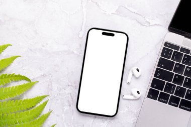 Yeşil doğa yapraklarıyla çevrili bir masada boş ekranı olan akıllı telefon, mükemmel tasarım modeli.