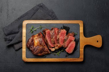 Lezzetli bir şekilde dilimlenmiş biftek, mükemmel pişmiş ve tadını çıkarmaya hazır. Düz yatıyordu