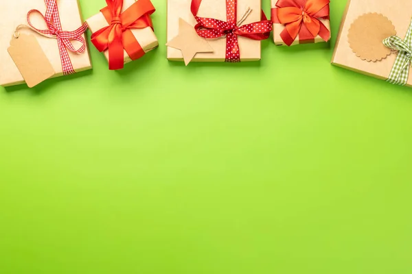 Christmas gift boxes over green backdrop and space for greetings text. Flat lay