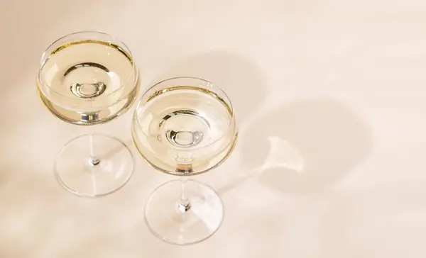 Twee Champagneglazen Een Beige Achtergrond Met Kopieerruimte — Stockfoto