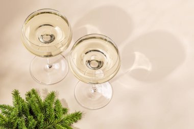 Bej arka planda fotokopi alanı olan iki şampanya bardağı. Noel tebrik kartı şablonu