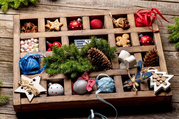Wooden box with Christmas decor and toys on wooden table