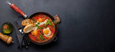 Tavada nefis shakshuka kahvaltısı. Kopyalama alanı olan düz